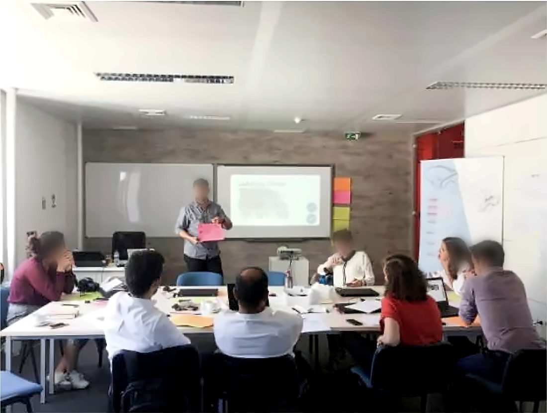 Facilitatore che presenta al gruppo in una sala workshop