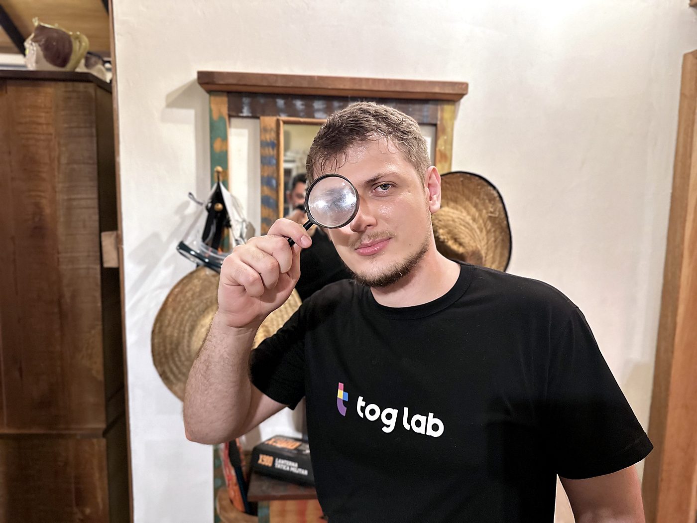 Una persona del team di Tog Lab con una lente d’ingrandimento davanti al viso e la maglietta di Tog Lab