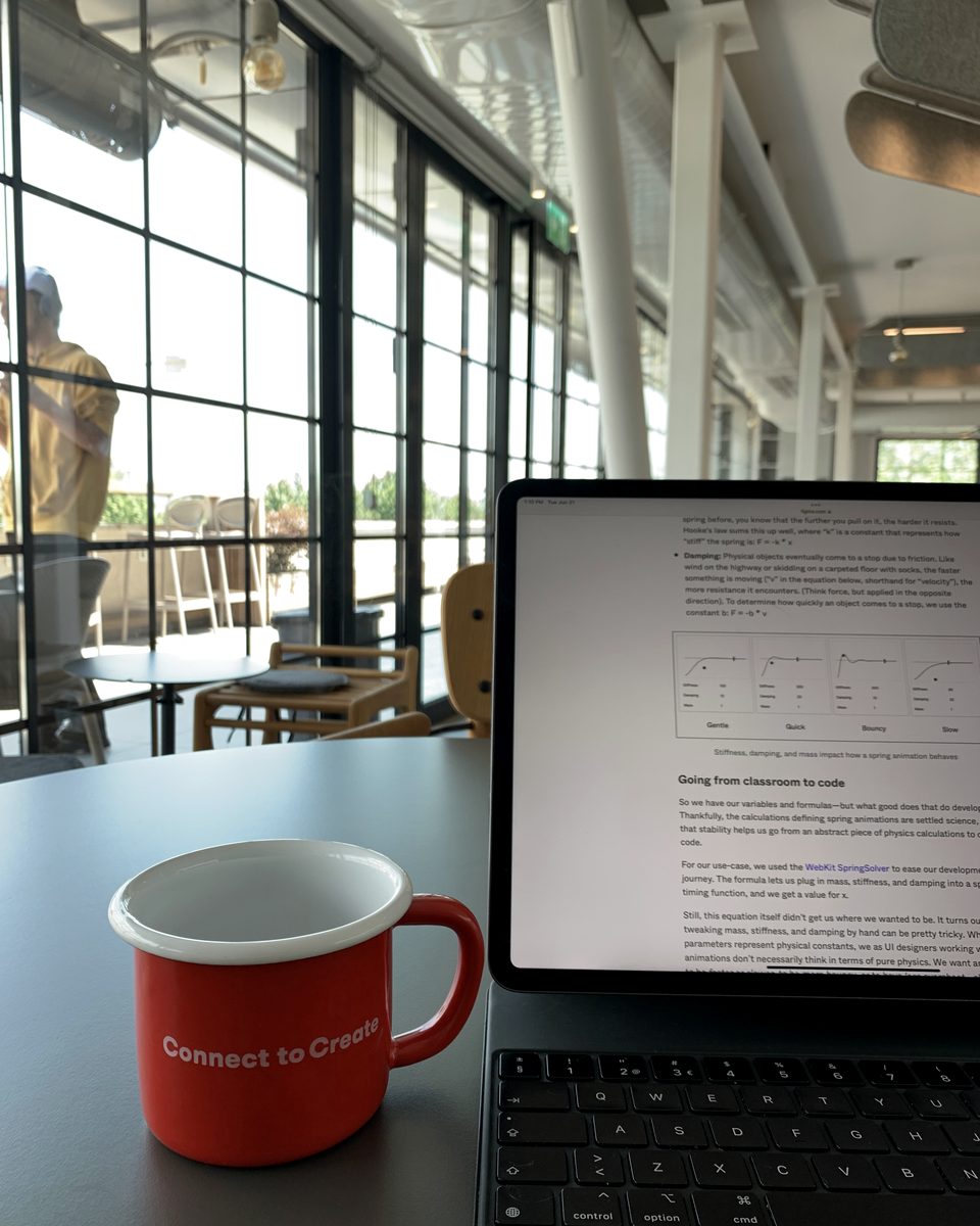 Una tazza rossa con la scritta Connect to Create accanto a un tablet in un caffè