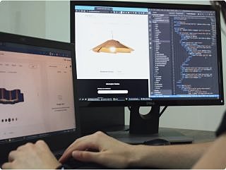 Mani sulla tastiera davanti a un monitor con del codice e l’anteprima di un prodotto
